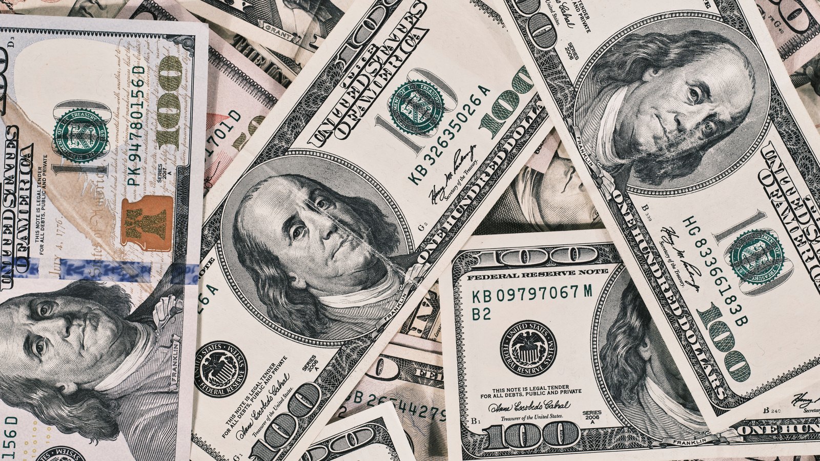 United States dollar bills arranged in an overlapping pattern.