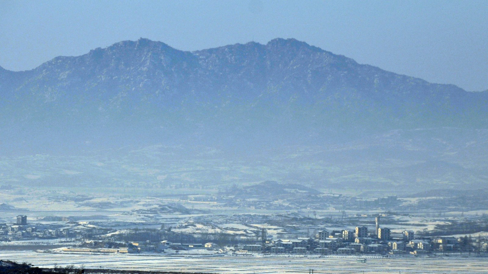 A snow-covered North Korean landscape viewed across the Demilitarized Zone.