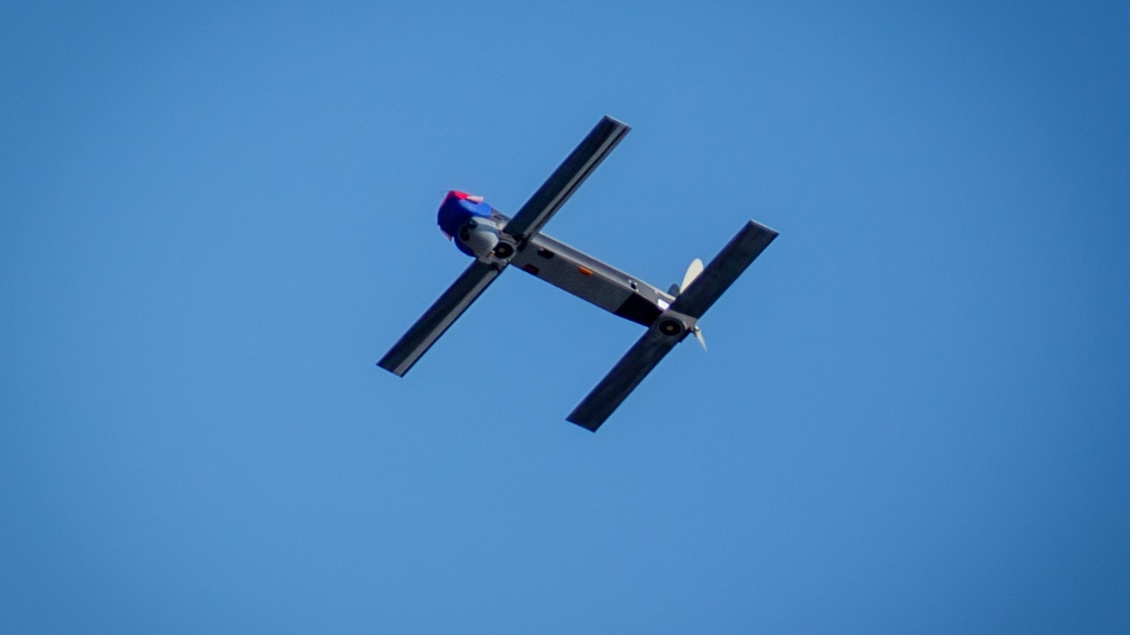 An AeroVironment Switchblade 300 flies against a blue sky.