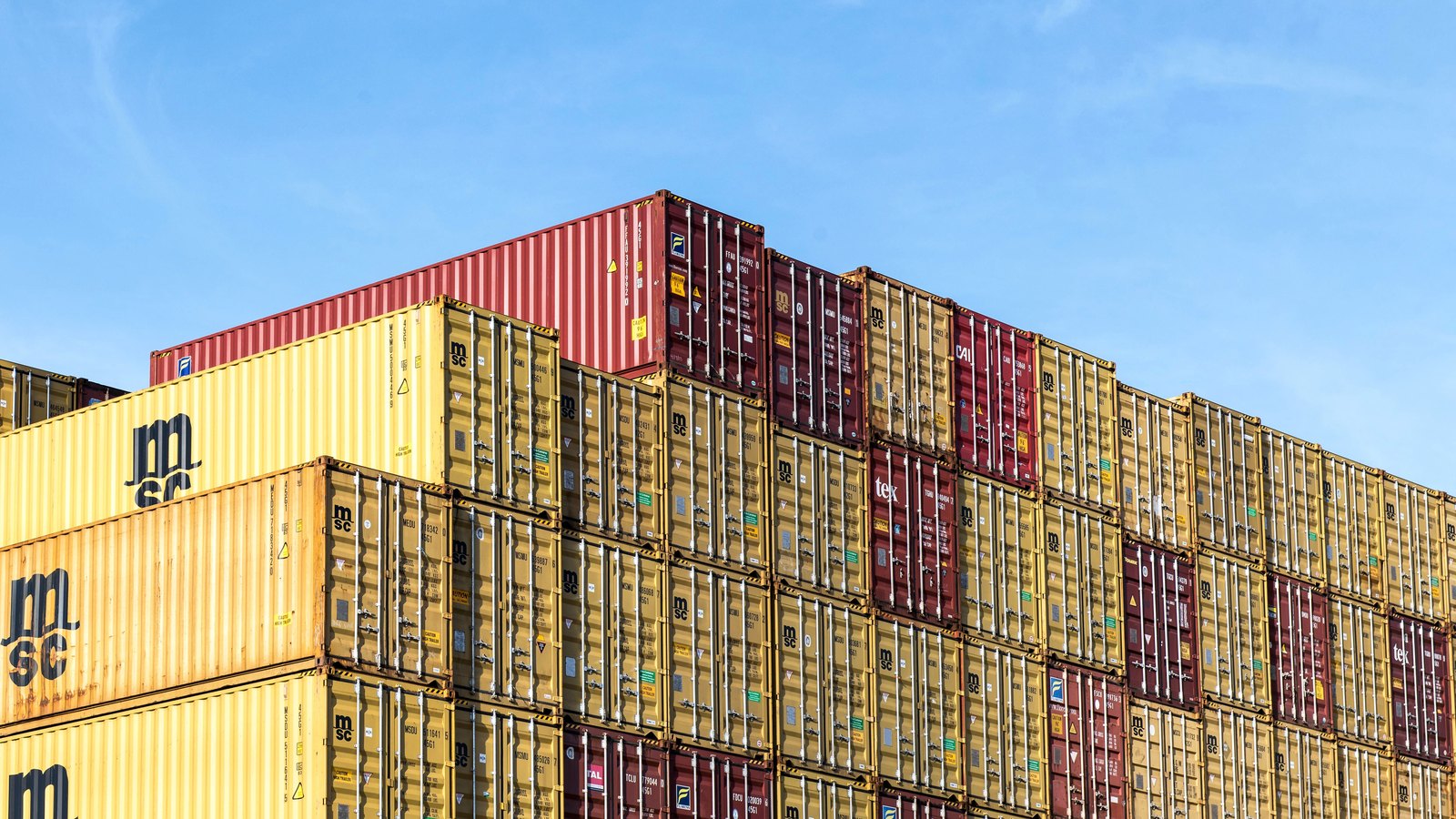 Shipping containers stacked several high at a port against a blue sky. A generic illustration of seaborne trade, not a photograph of any shipment in this story.