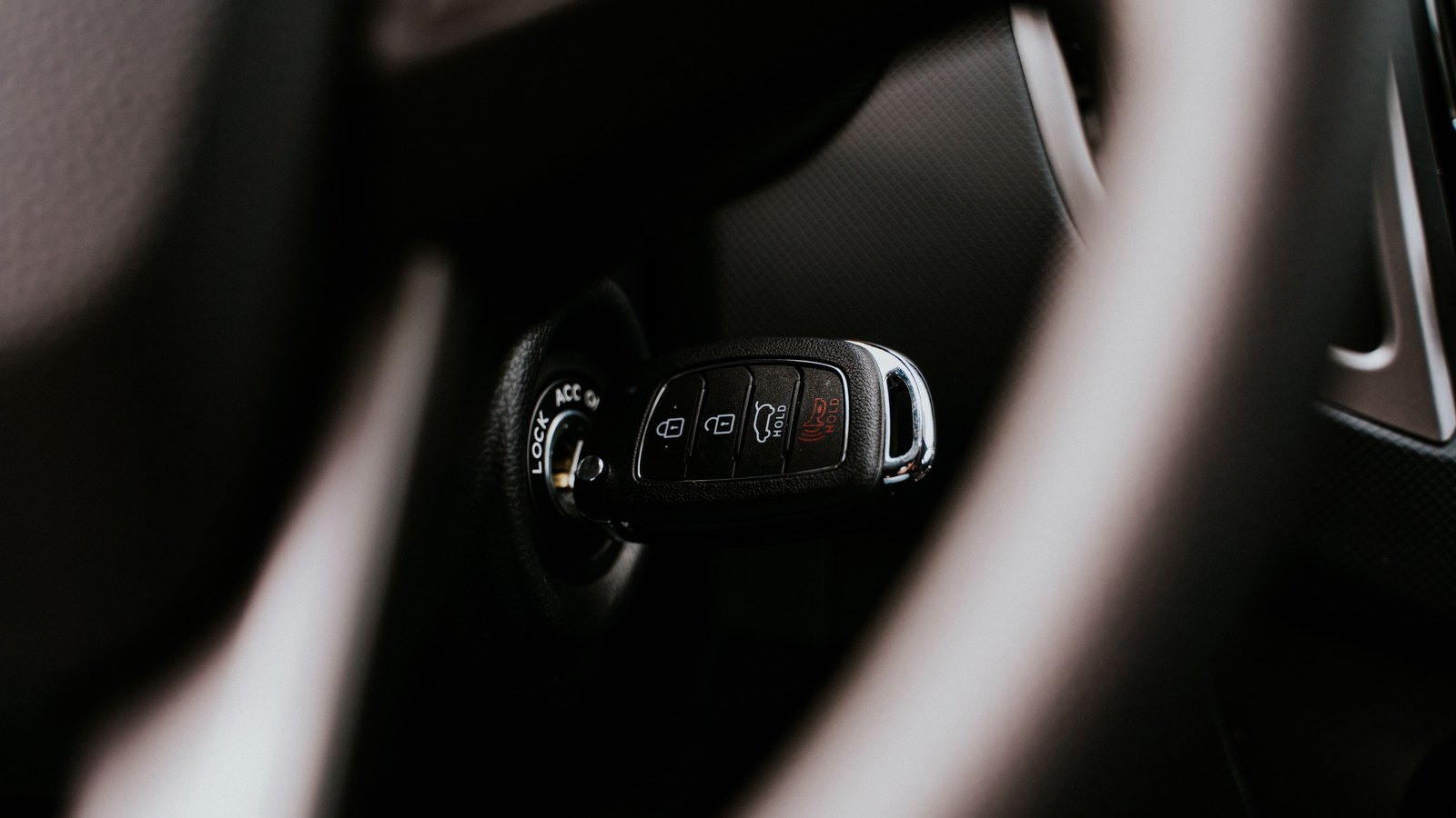 A car key in an ignition, shown in close-up. Illustrative stock photograph.