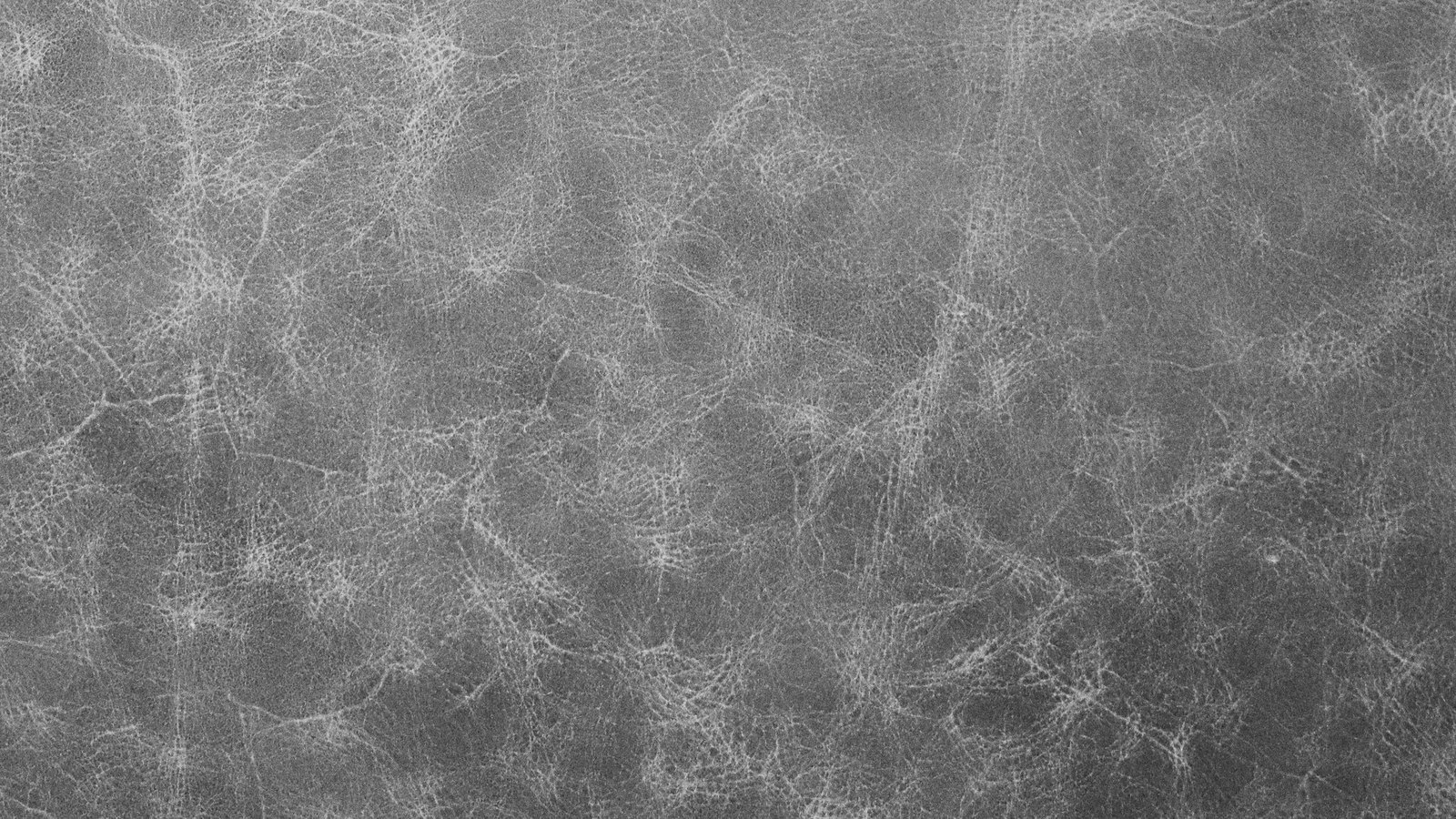 A close view of grey leather, the grain running in fine pale lines across a flat, even surface.