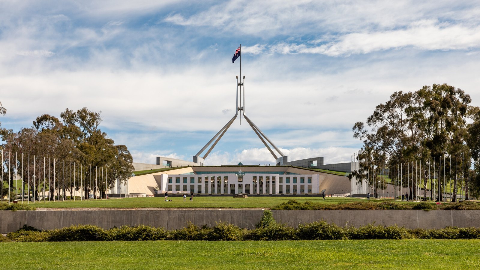 The front of Australian Parliament House in Canberra beneath its flag mast.