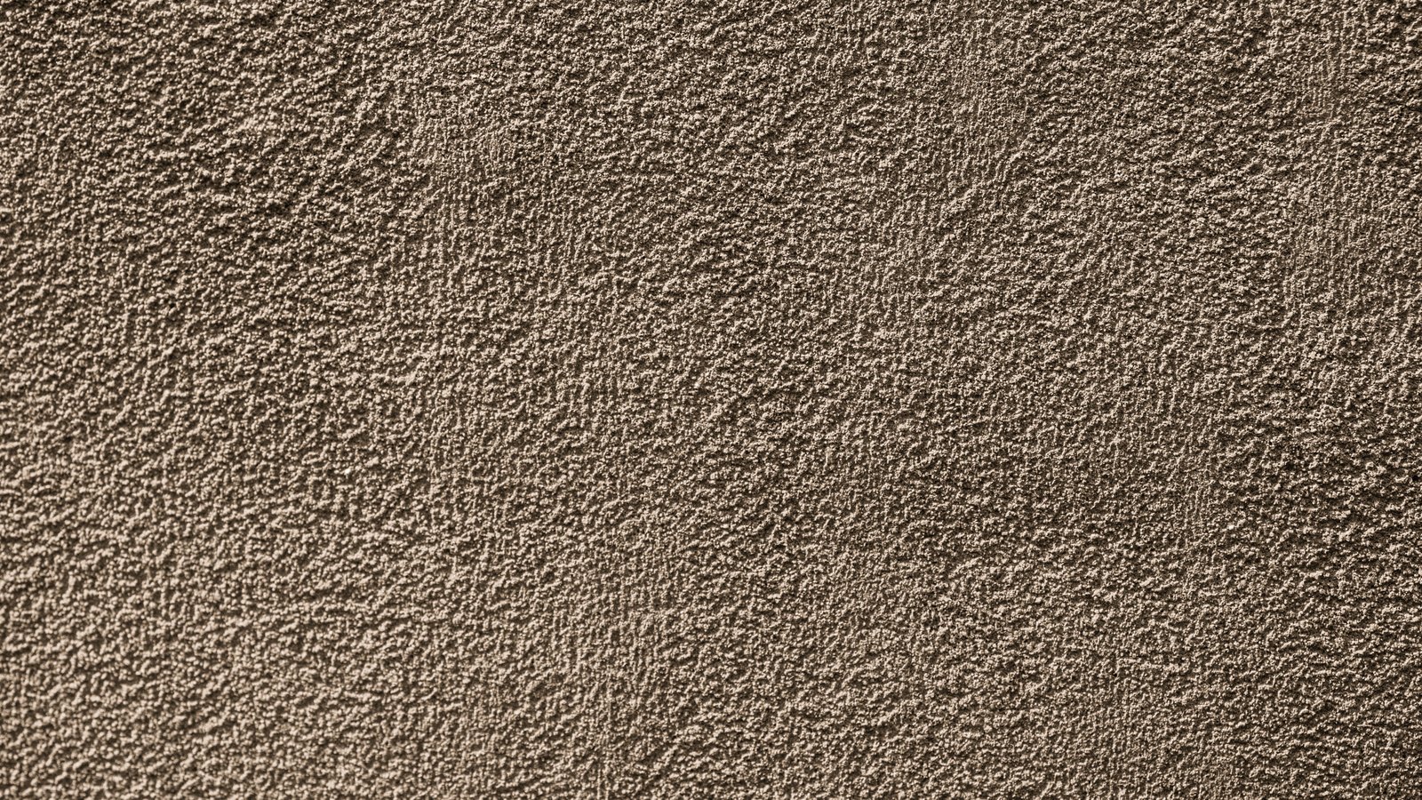 A close photograph of a warm brown matte surface filling the entire frame, its fine granular texture raised into thousands of small even peaks that catch a soft light falling from the upper left. No text, markings, brand marks, people or objects are in view. A generic material close-up, not a photograph of any fund, filing, exchange or office.