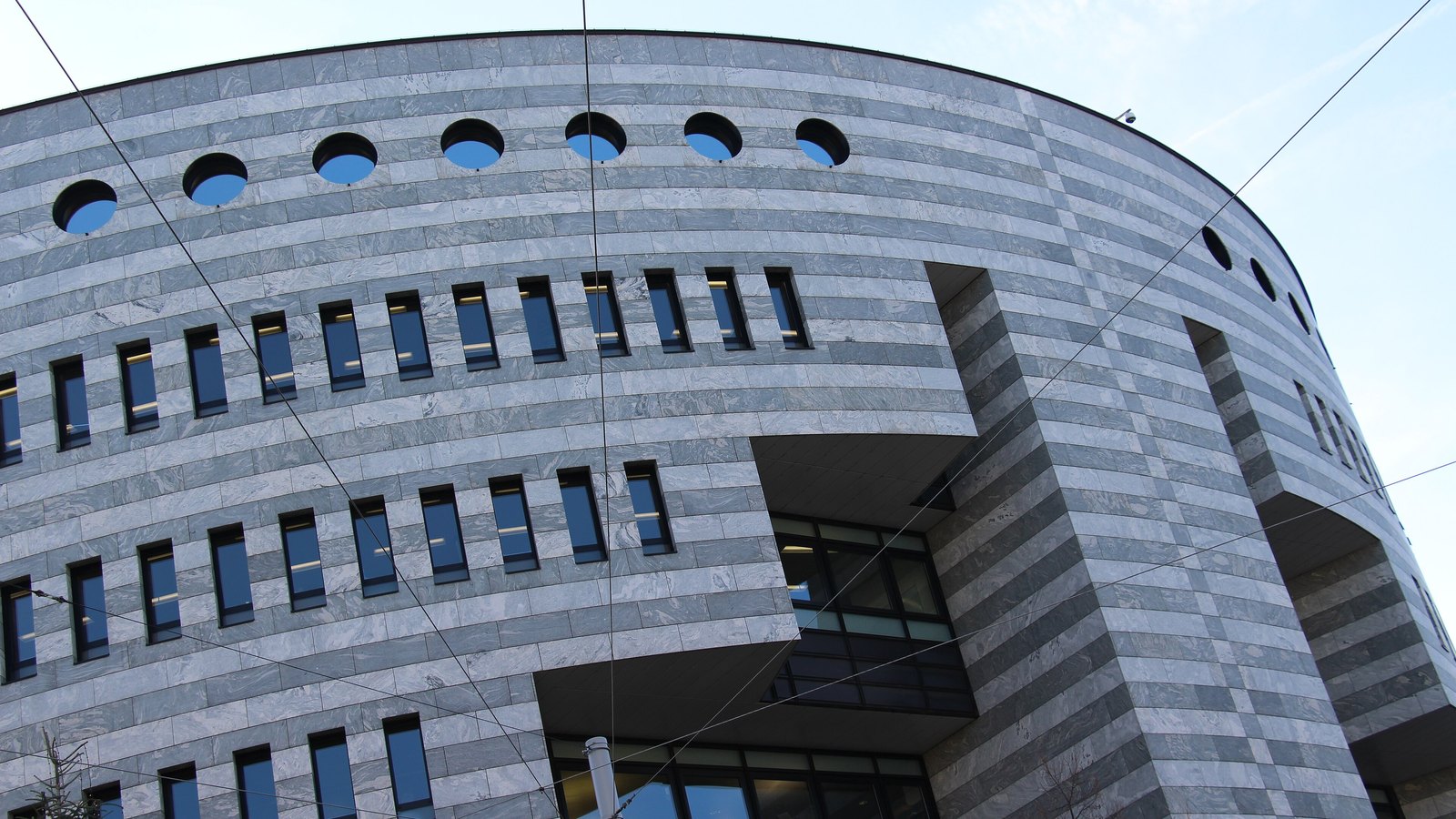 The curved grey stone facade of the Bank for International Settlements Botta building in Basel.