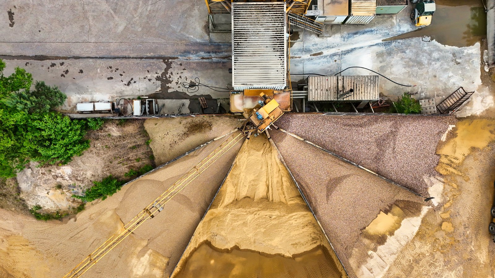 An aerial view of an operating sand and gravel quarry with conveyors and heavy machinery, not a photograph of Bell Mine or this event.