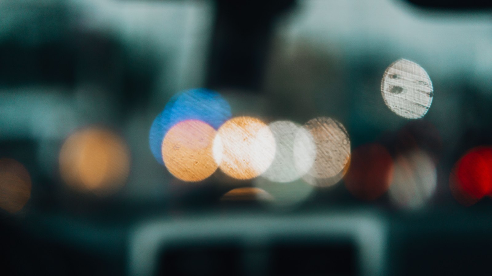 Red and blue lights blur through rain on a windshield in a generic nighttime traffic photograph, not a photograph of this crash.