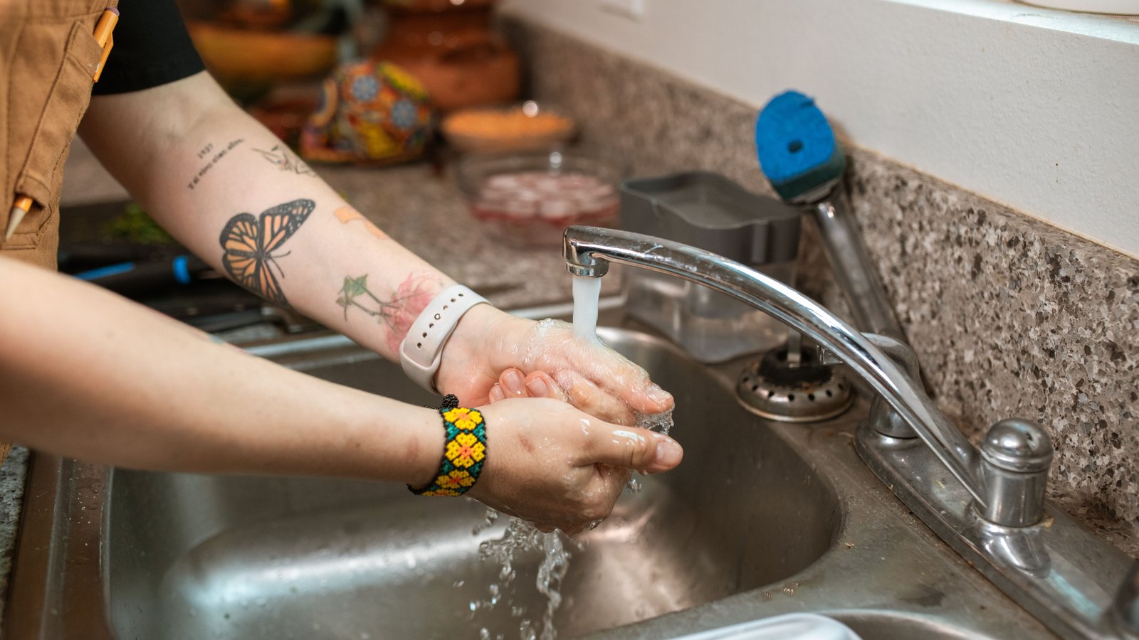 Hands are washed under a running kitchen faucet, not a photograph of this advisory.
