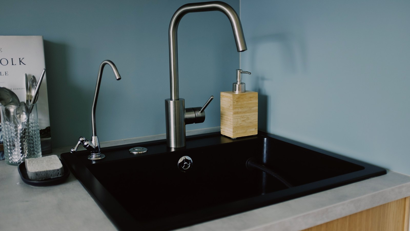 Stainless kitchen faucet over a black sink, not a photograph of this event.