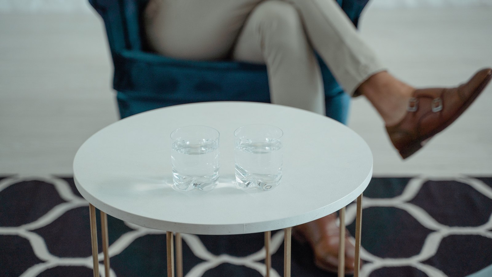 Two glasses of water on a round white table, not a photograph of this event.