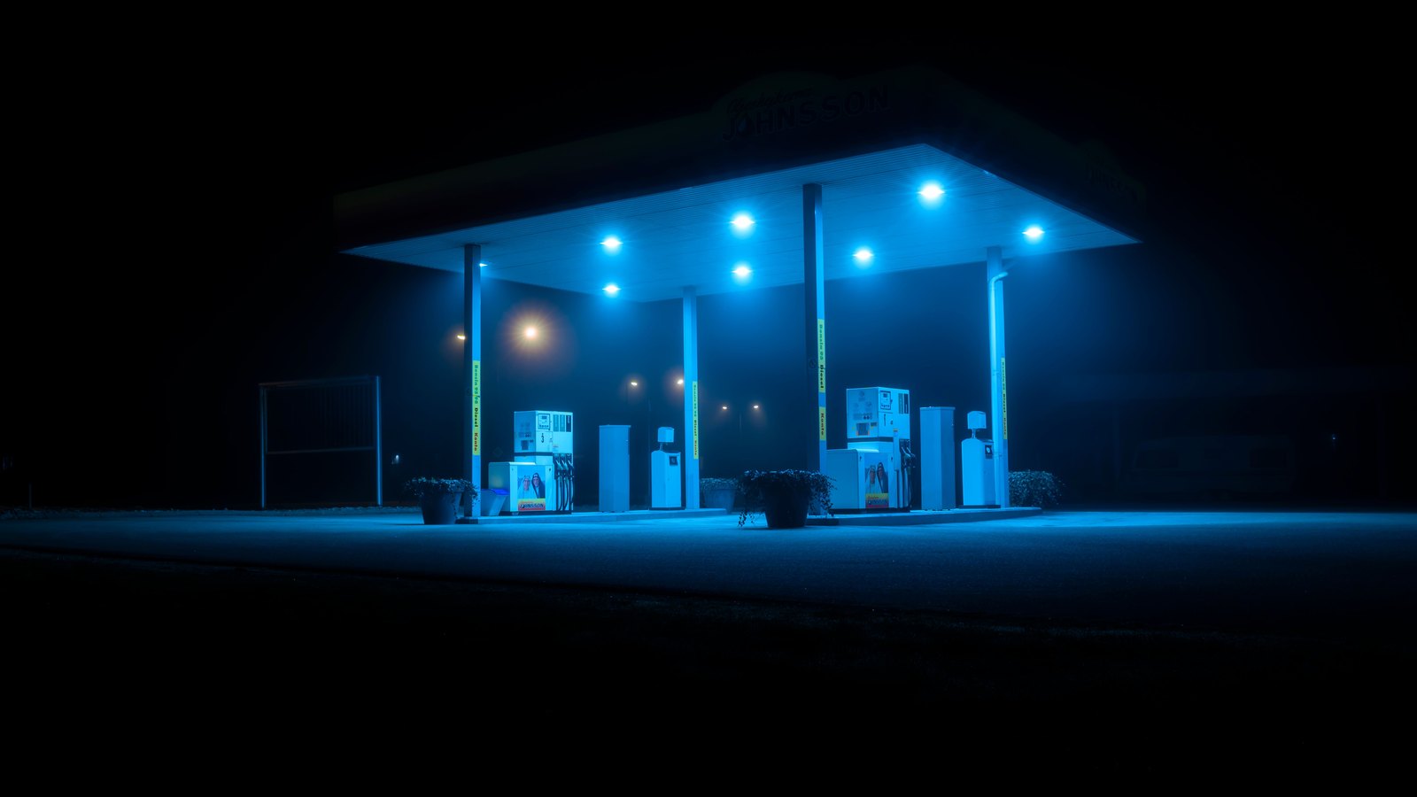 An empty gas station canopy glowing blue at night, not the Cape Coral scene.