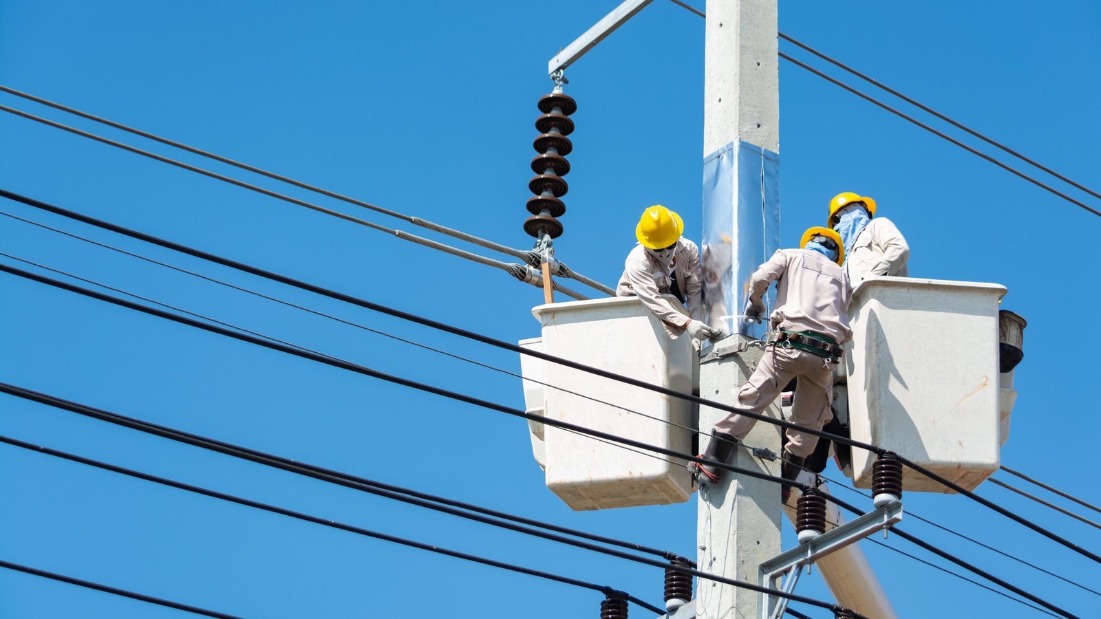 Utility workers in raised buckets repair power lines against a blue sky, not a photograph of this event.