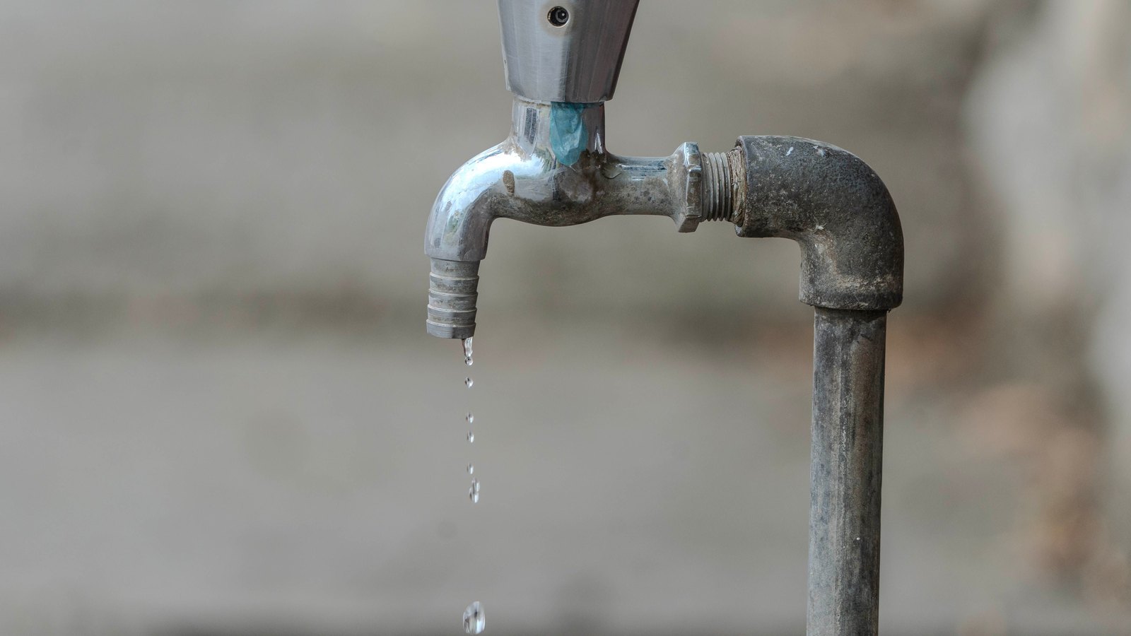 Water drips from a plain outdoor tap, not a photograph of this event.