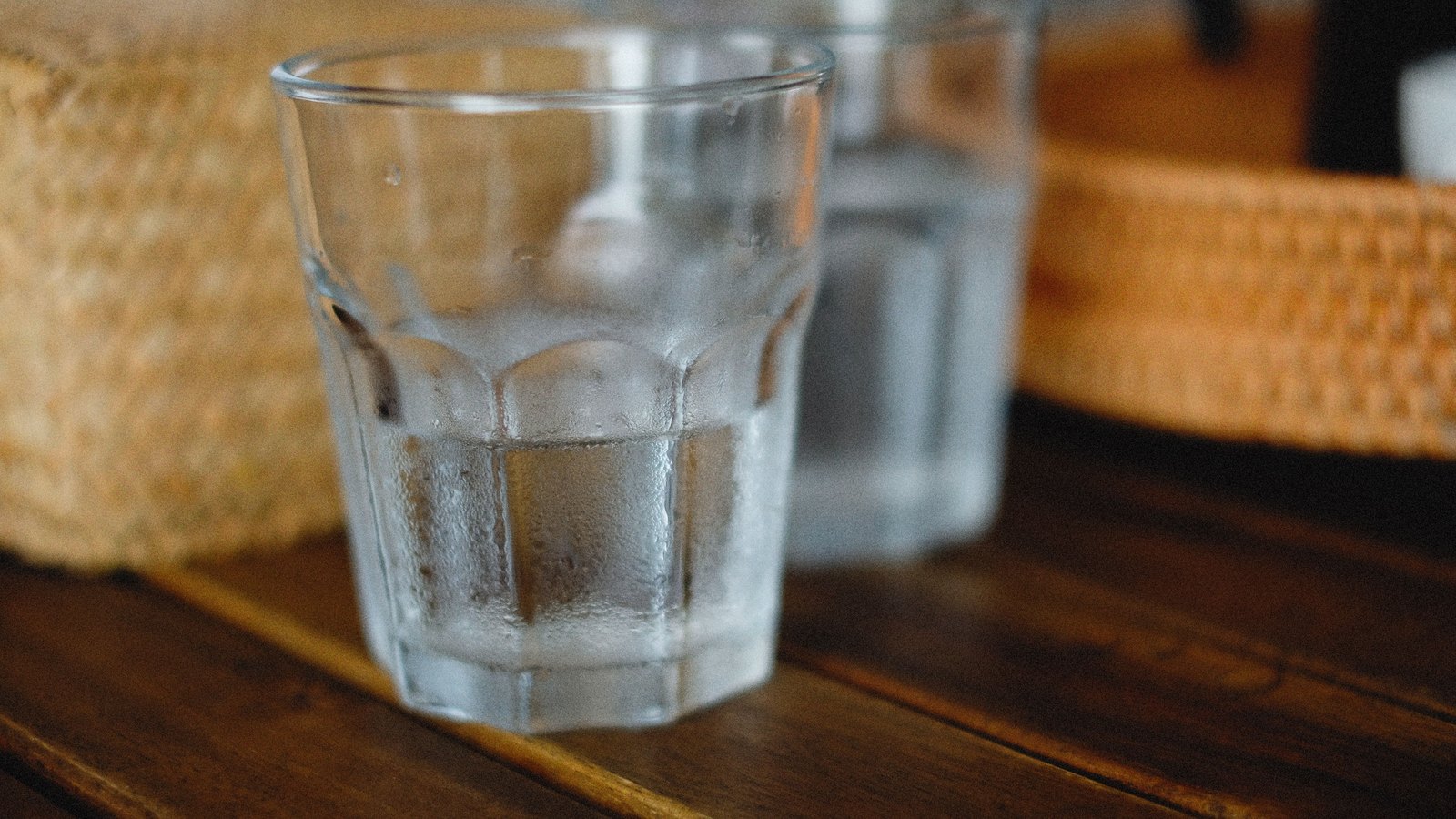 A clear glass of water on a wooden table, not a photograph of this event.