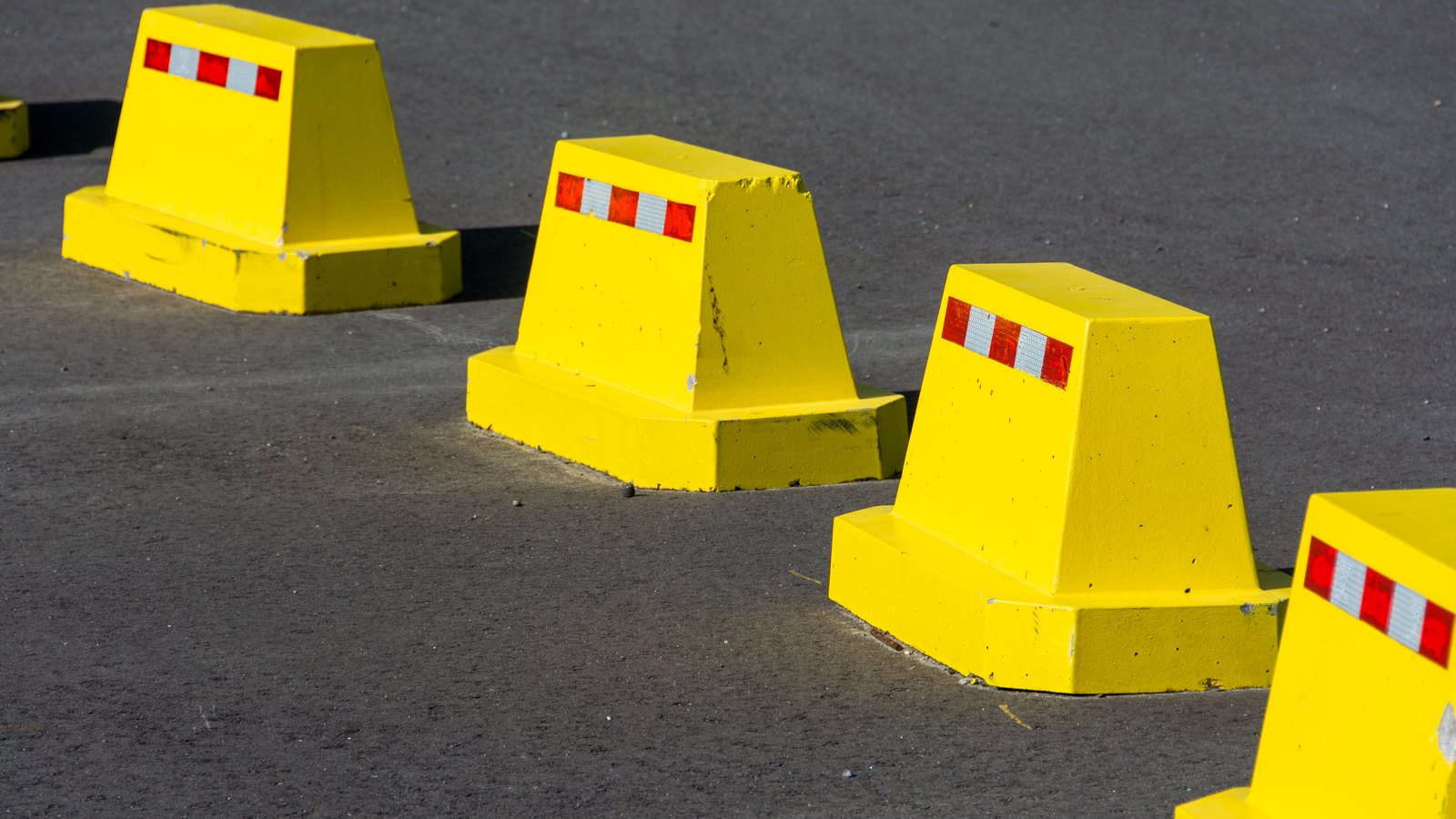 Bright yellow traffic barriers line an asphalt roadway, not a photograph of this closure.