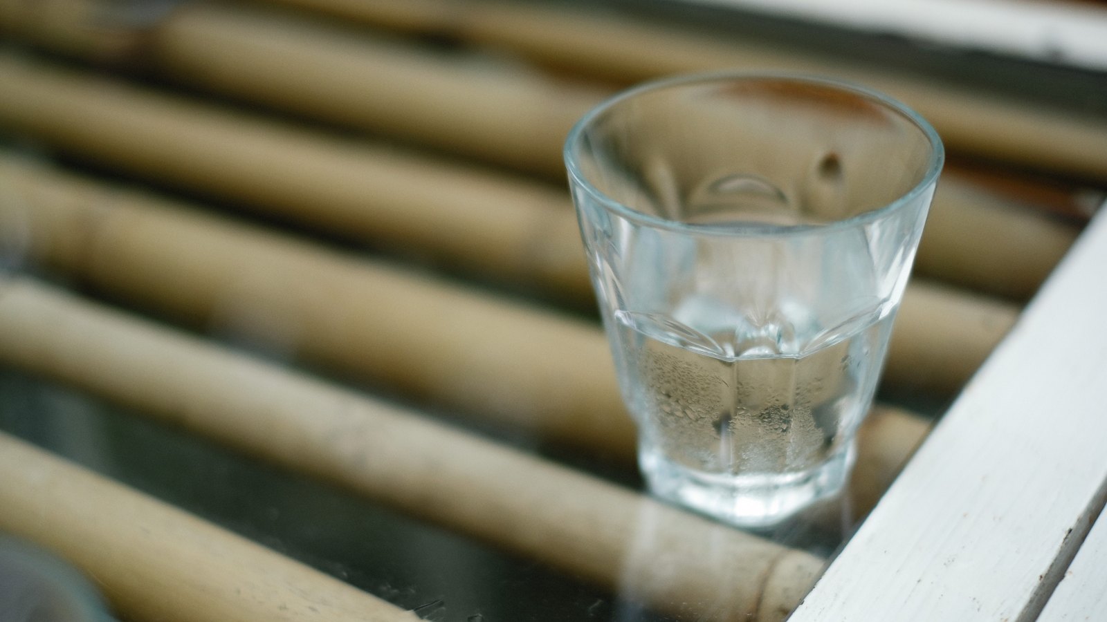 A clear glass holding water sits on a slatted surface, not a photograph of this advisory.