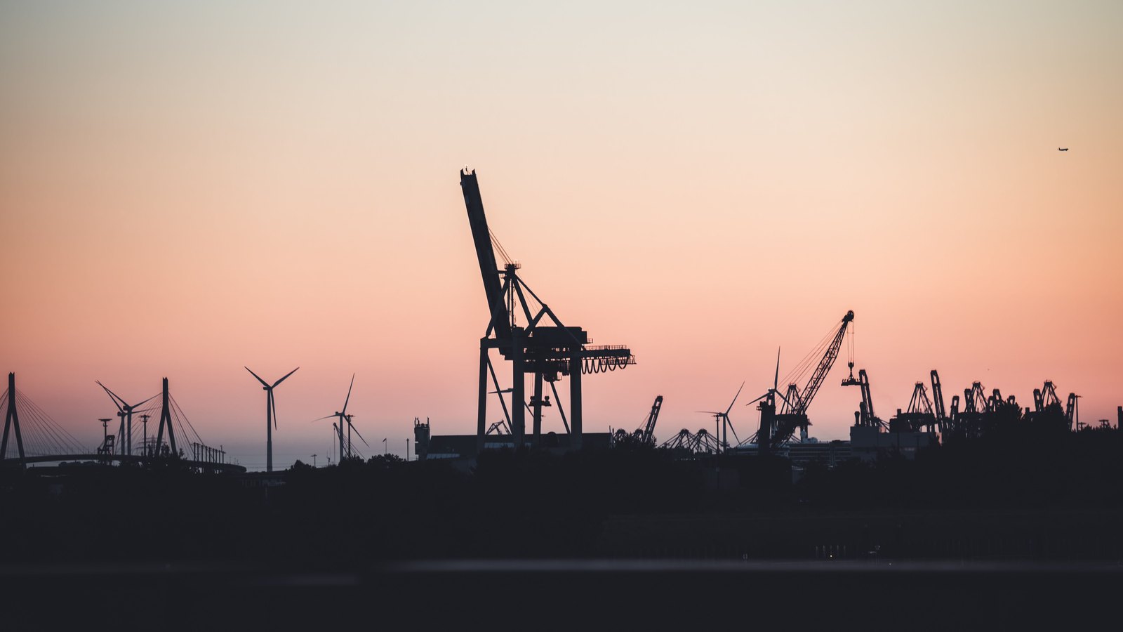 A photograph illustrating port cranes silhouette.