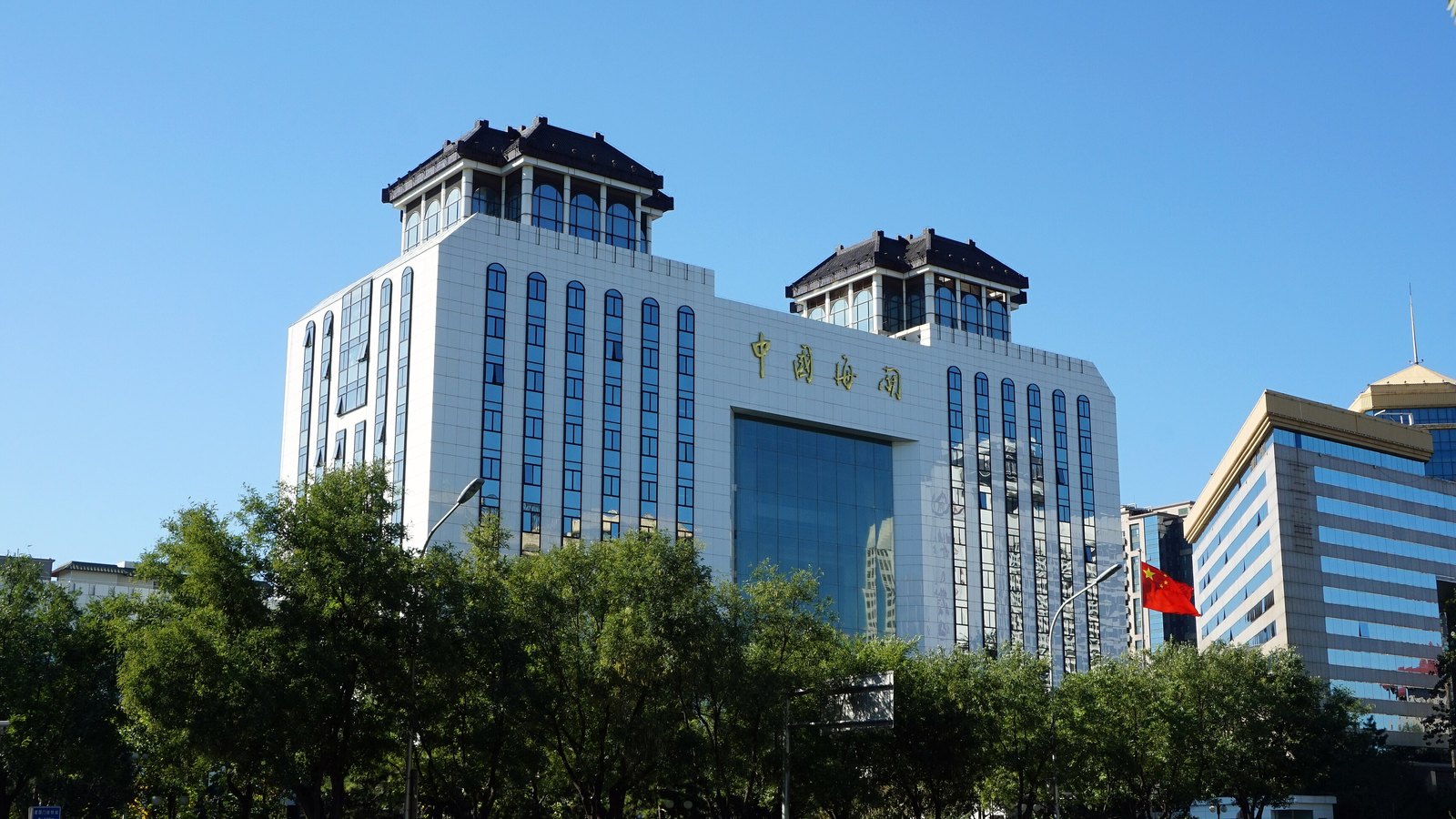 The General Administration of Customs building in Beijing, with gold China Customs lettering and a Chinese flag above the entrance.