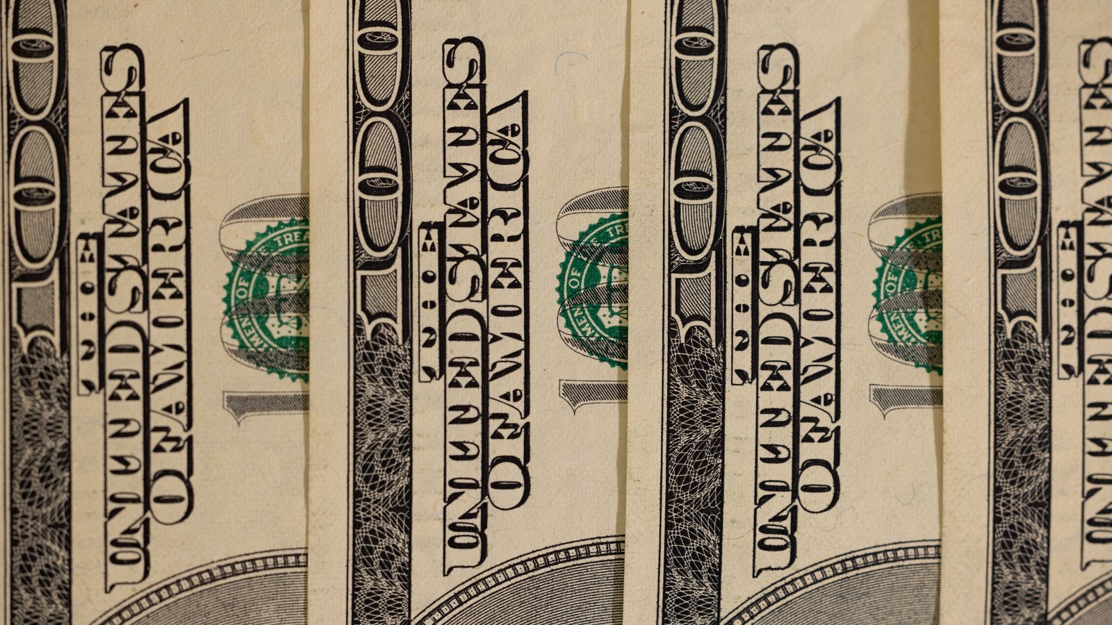 A photograph illustrating hundred dollar bills closeup.