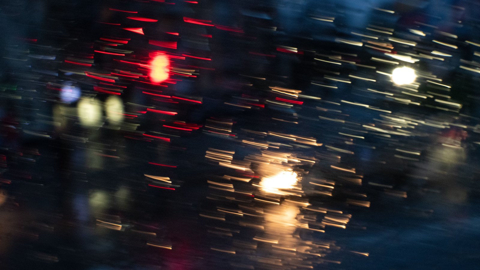 Rain and blurred vehicle lights seen through a windshield, not a photograph of this event.