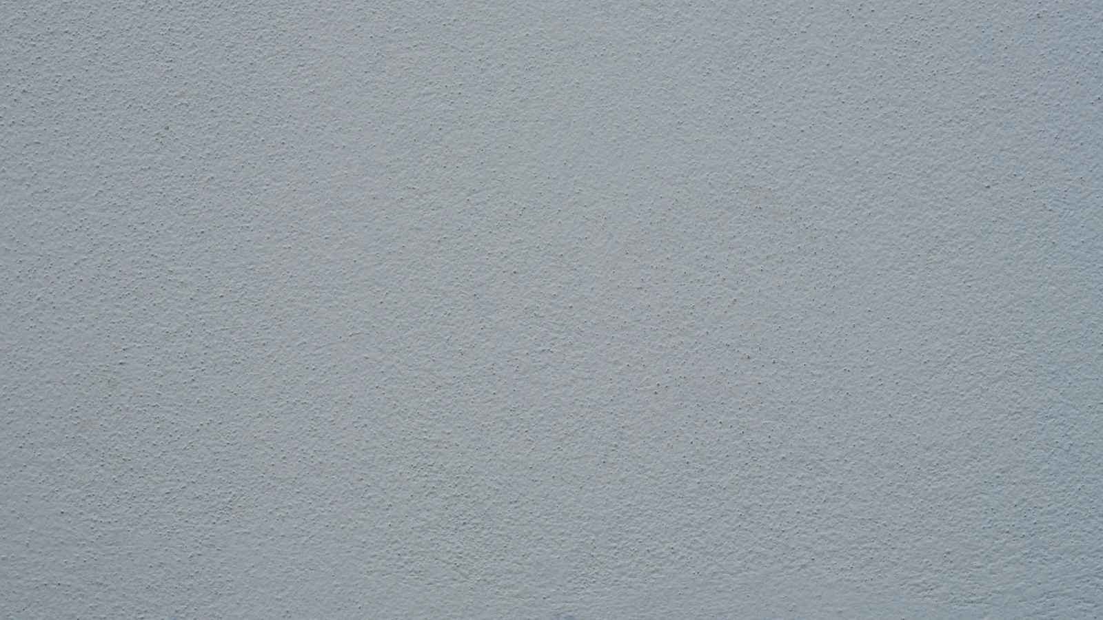 A flat, evenly lit crop of a pale grey rendered wall, its fine sand texture and scattered small pits filling the whole frame. No lettering, object, person or place is visible. A generic wall texture, not a photograph of any Collier County property or building.