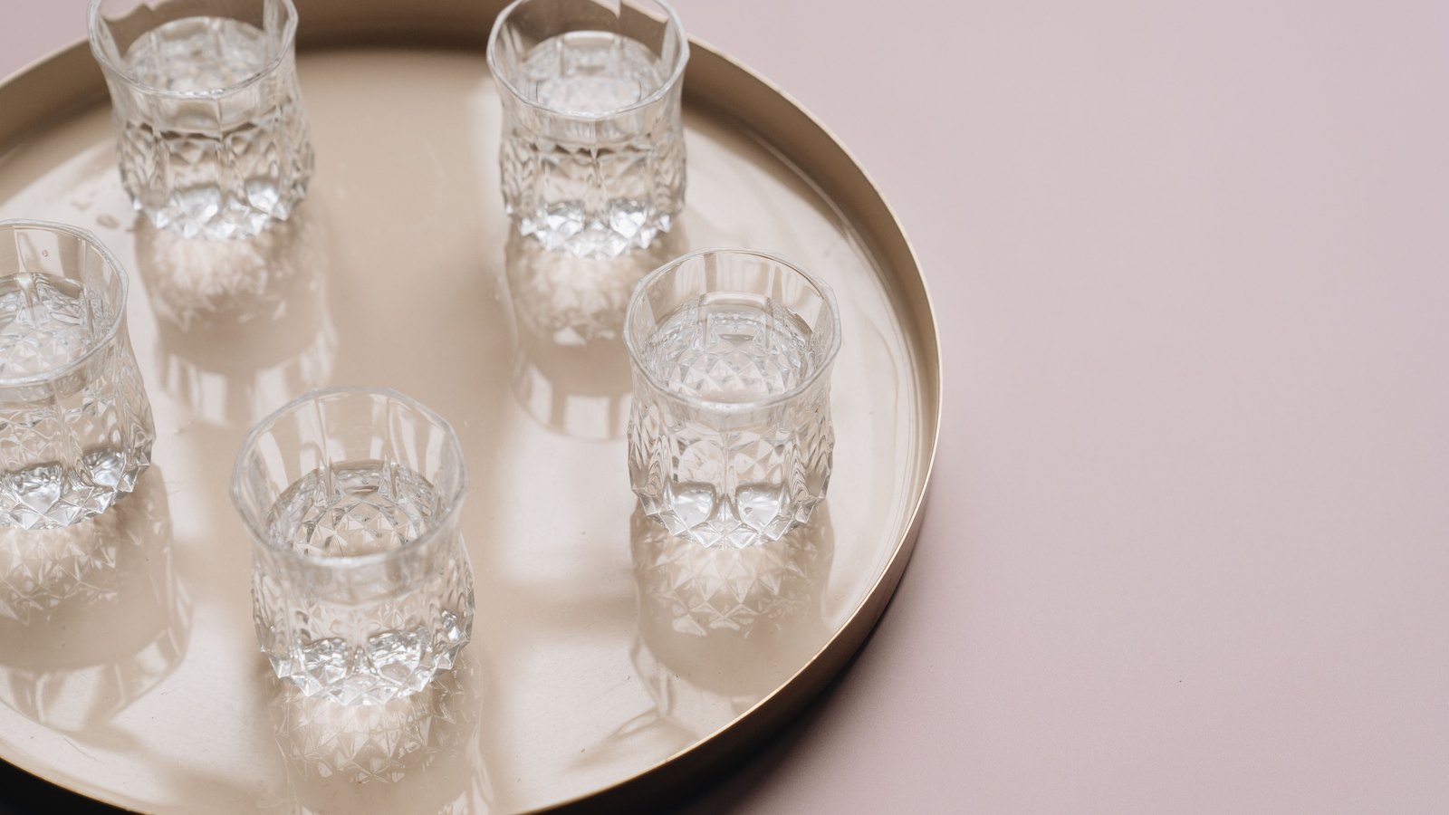 Five clear glasses of water rest on a round tray, not a photograph of this advisory.