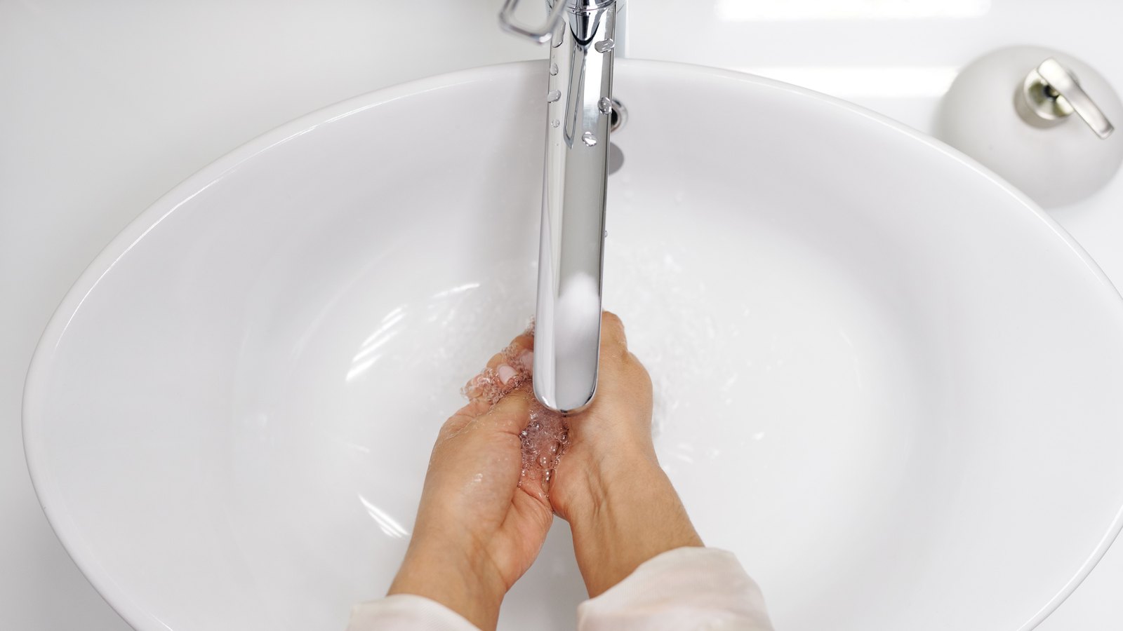 Hands are washed under a running faucet, not a photograph of this notice.