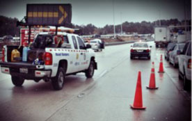 A response truck and orange cones close a highway lane, not a photograph of this event.