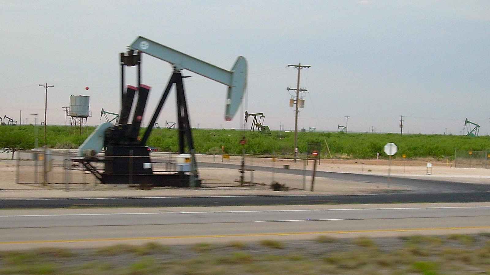 Pumpjacks operate beside a road in West Texas.