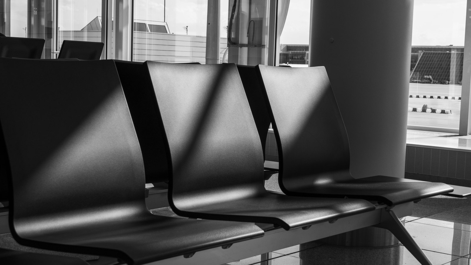 A photograph illustrating empty waiting room chairs.