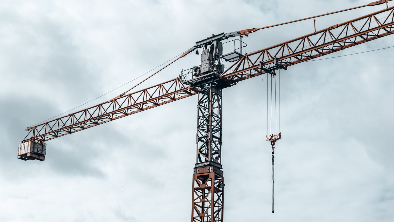 A tower crane stands against a cloudy sky, not a photograph of these projects.