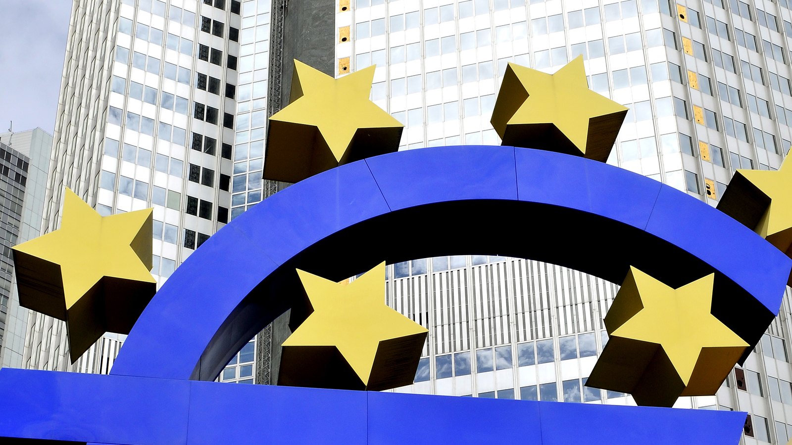 The blue euro sculpture and yellow stars stand before the former European Central Bank headquarters in Frankfurt.