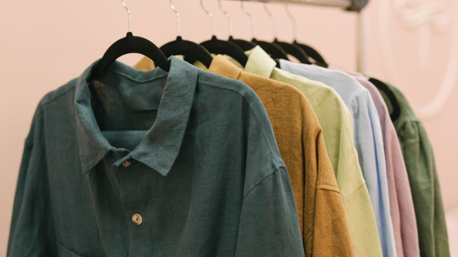 A row of colorful shirts hanging on a clothing rack.