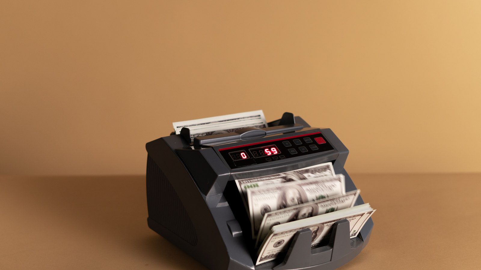 A money-counting machine processes United States dollar bills.