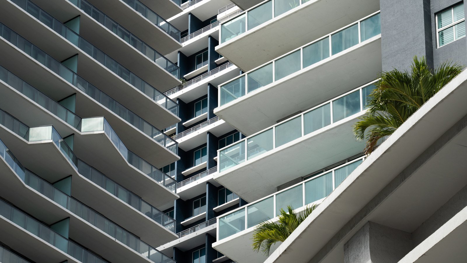 Close view of modern condominium balconies with palms, not a photograph of any association in the database.