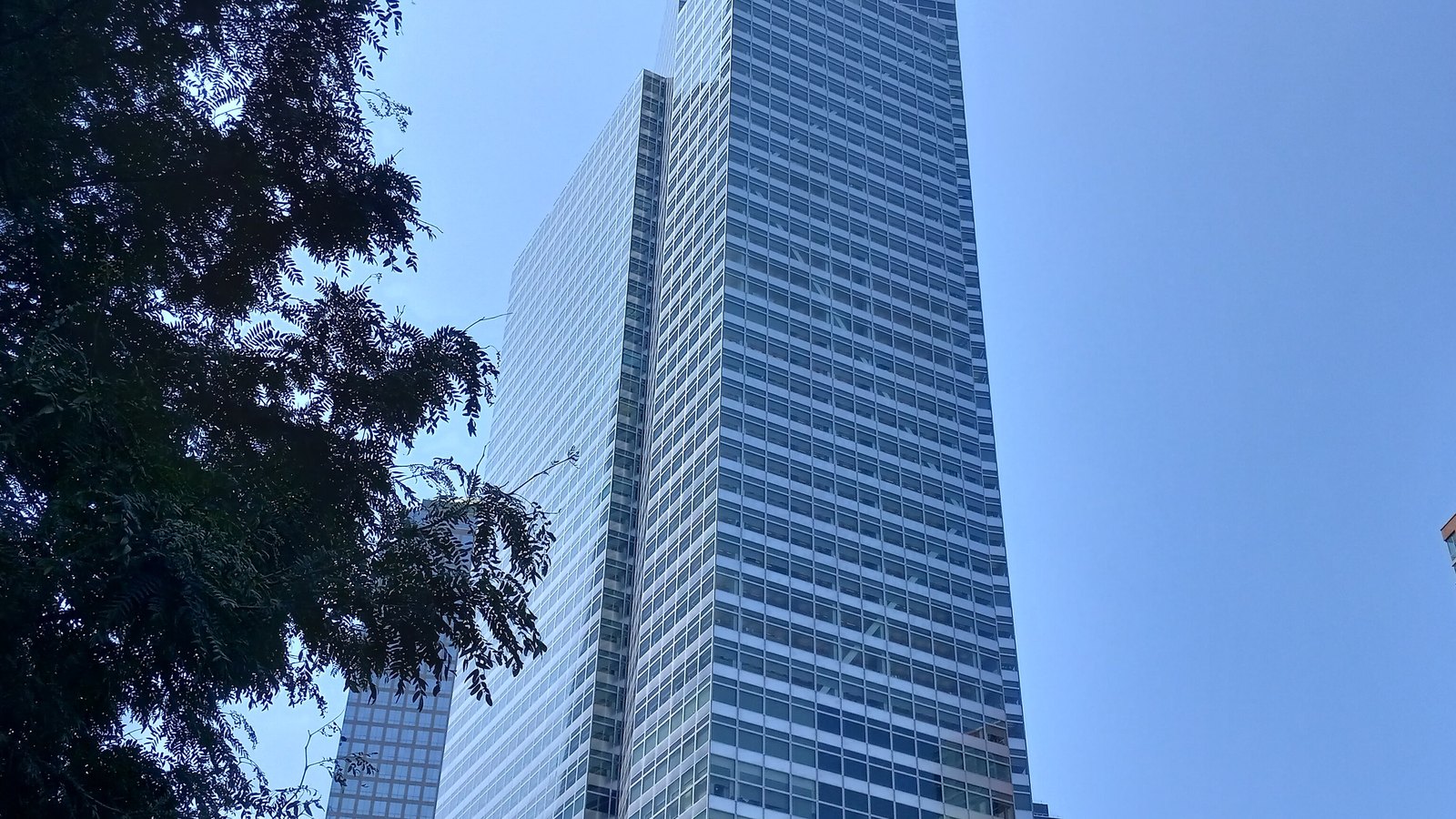 Goldman Sachs headquarters at 200 West Street in Manhattan, seen beside leafy trees.