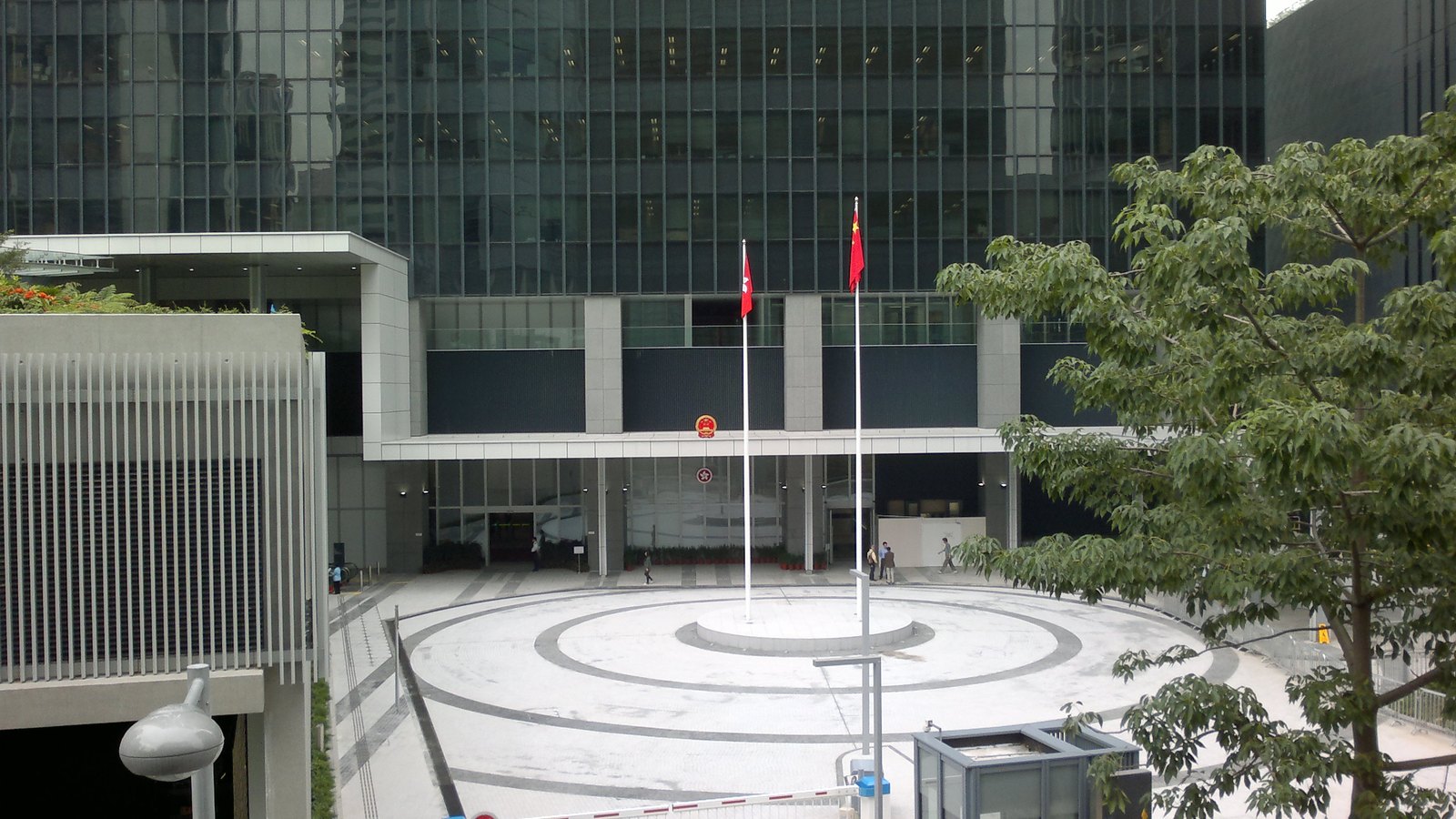 The east entrance of the Hong Kong Central Government Offices, with the Hong Kong and Chinese flags outside.