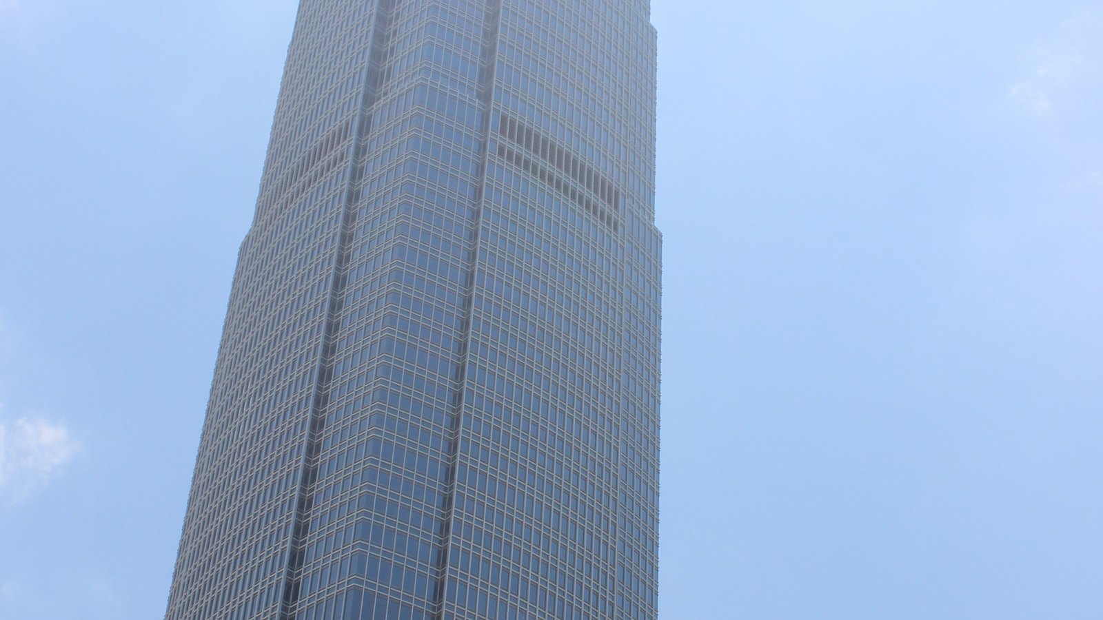Two International Finance Centre rises against a blue sky in Hong Kong.