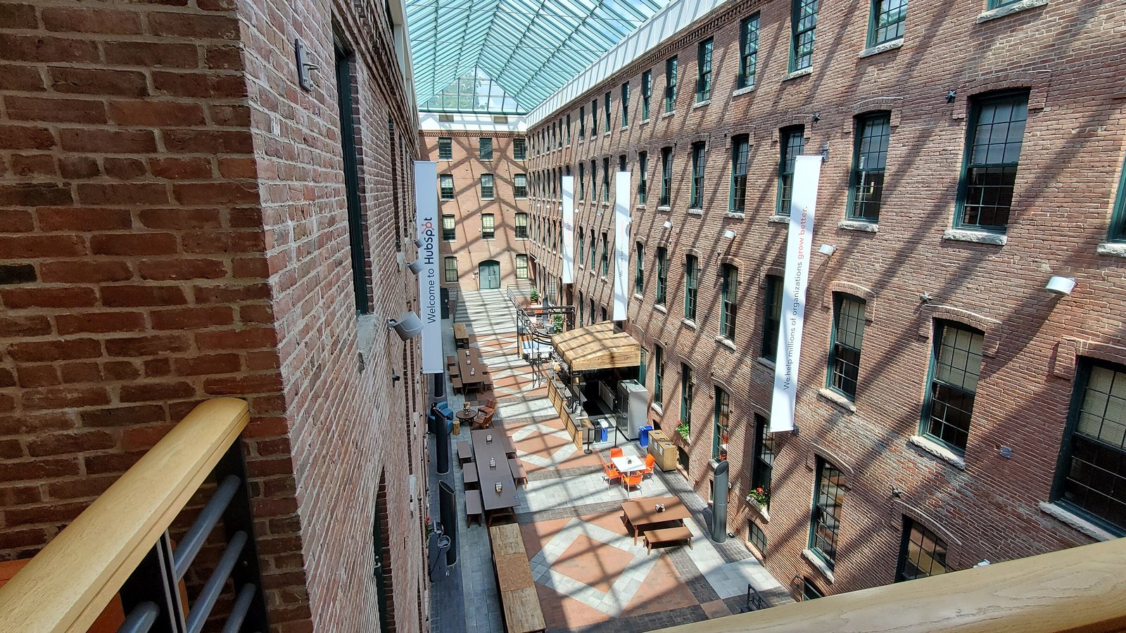 An empty brick atrium inside HubSpot headquarters, with company banners hanging between the buildings.