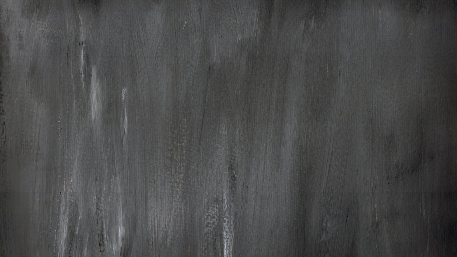 A photograph illustrating dark grey brushed metal surface texture.