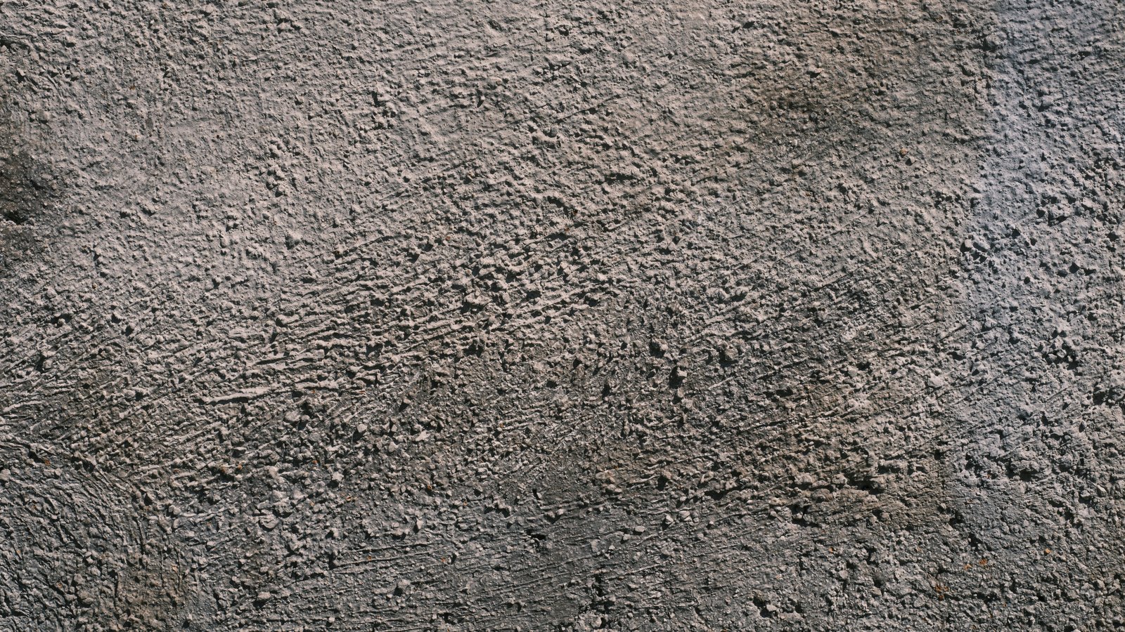 A close crop of a rough grey concrete surface, used as an illustration. It carries no signage, no vehicle and no person, and it is not a photograph of Interstate 75.