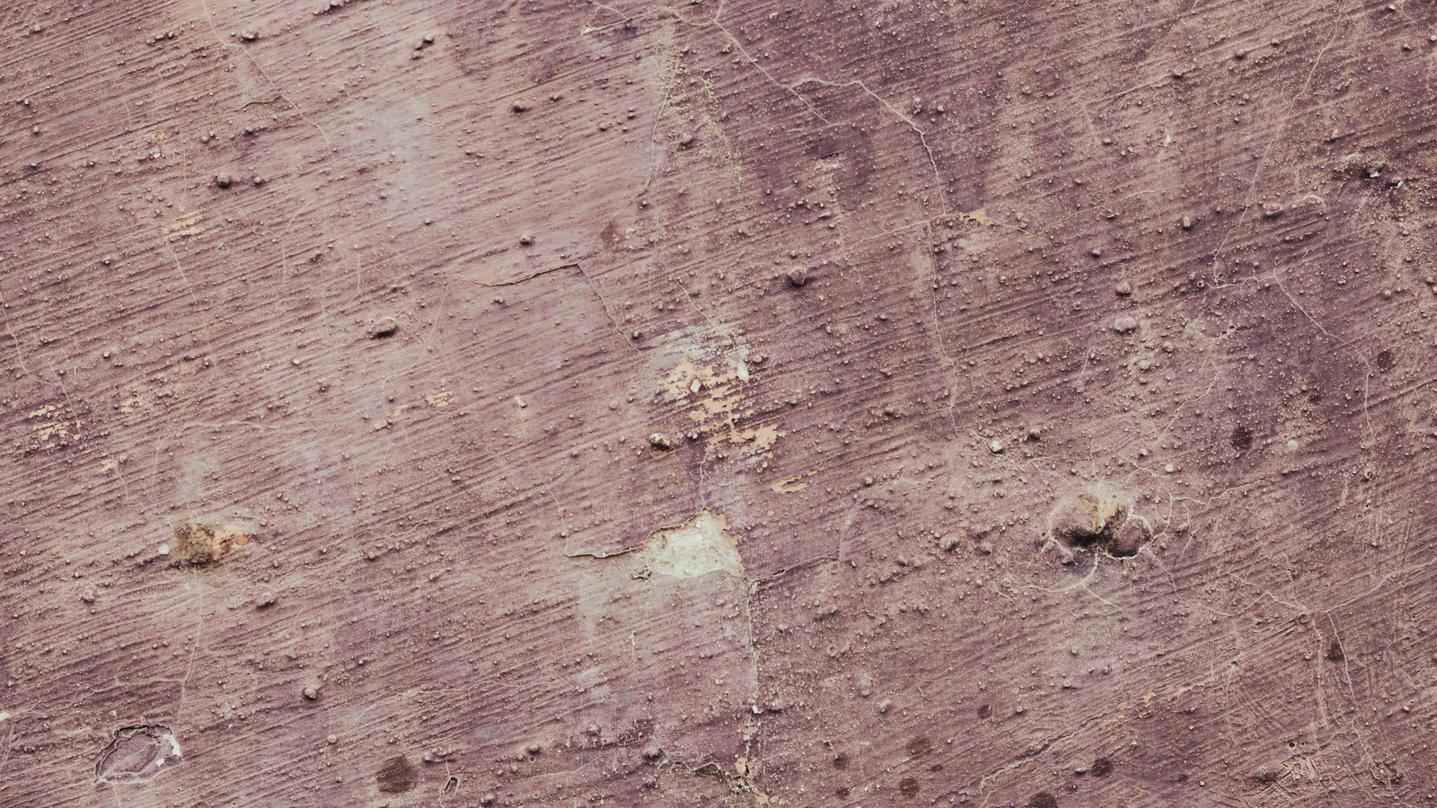 A close crop of a weathered mauve rendered wall, used as an illustration. It is not a photograph of Interstate 75.