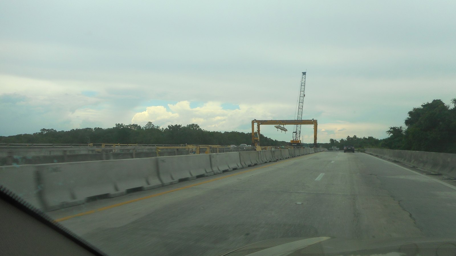 Construction cranes and concrete barriers in the median of Interstate 75 elsewhere in Florida, not a photograph of this Exit 101 work.
