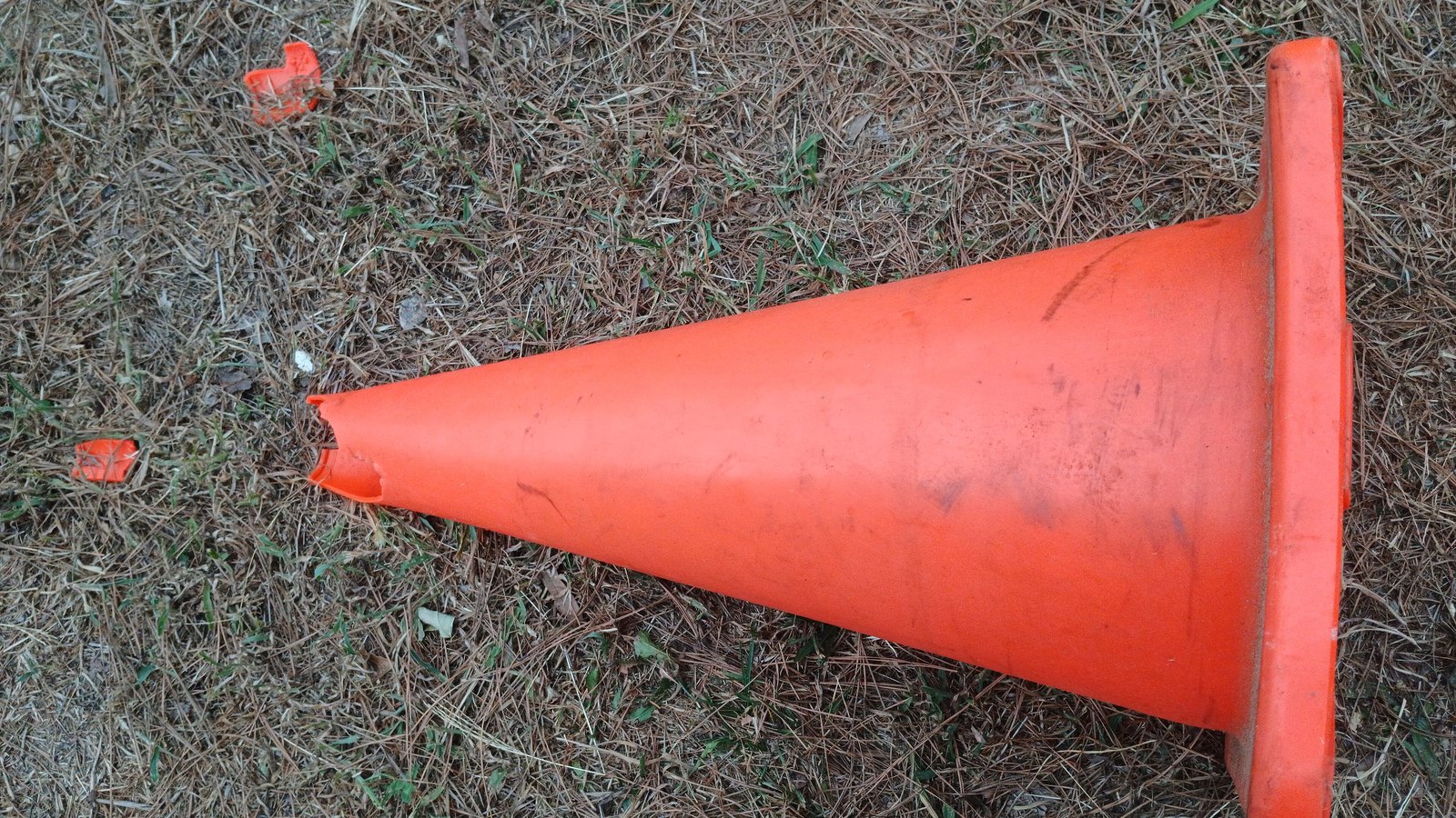 A generic orange traffic cone lies on grass, not a photograph of this closure.