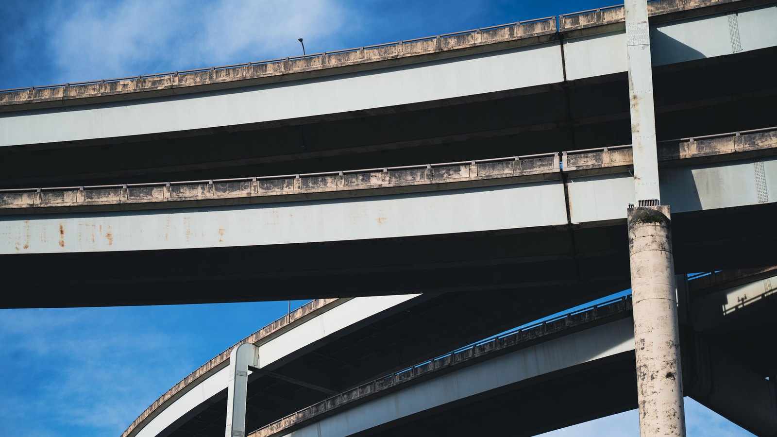 Stacked concrete highway ramps cross beneath a clear sky with no visible sign, person, logo or identifiable location. A stock photograph, not a photograph of this project.