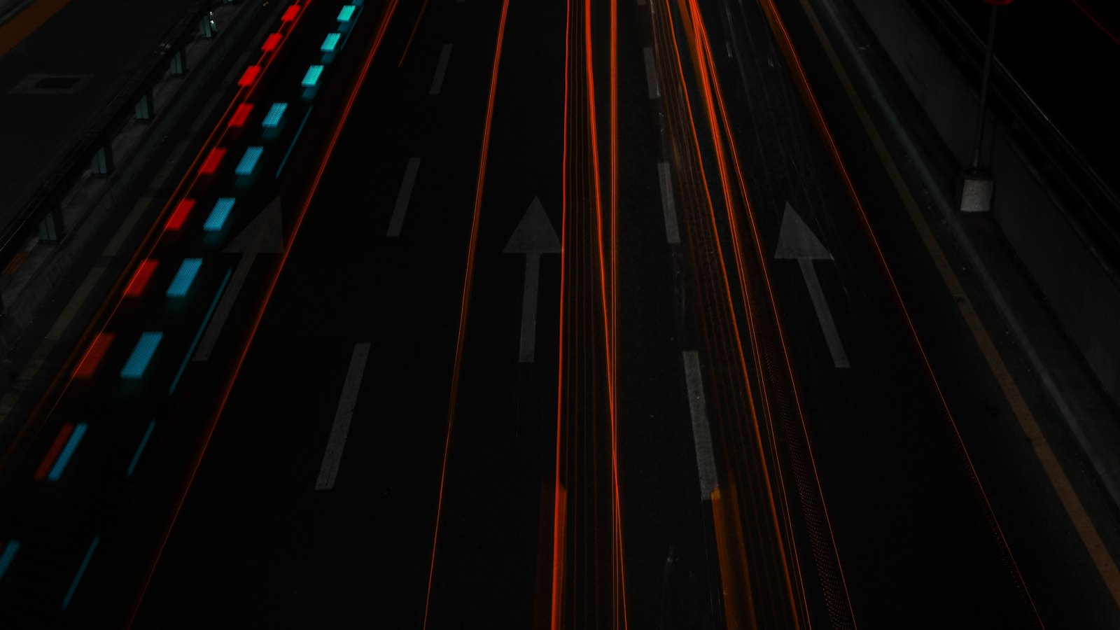 Light trails move along a multilane highway after dark.
