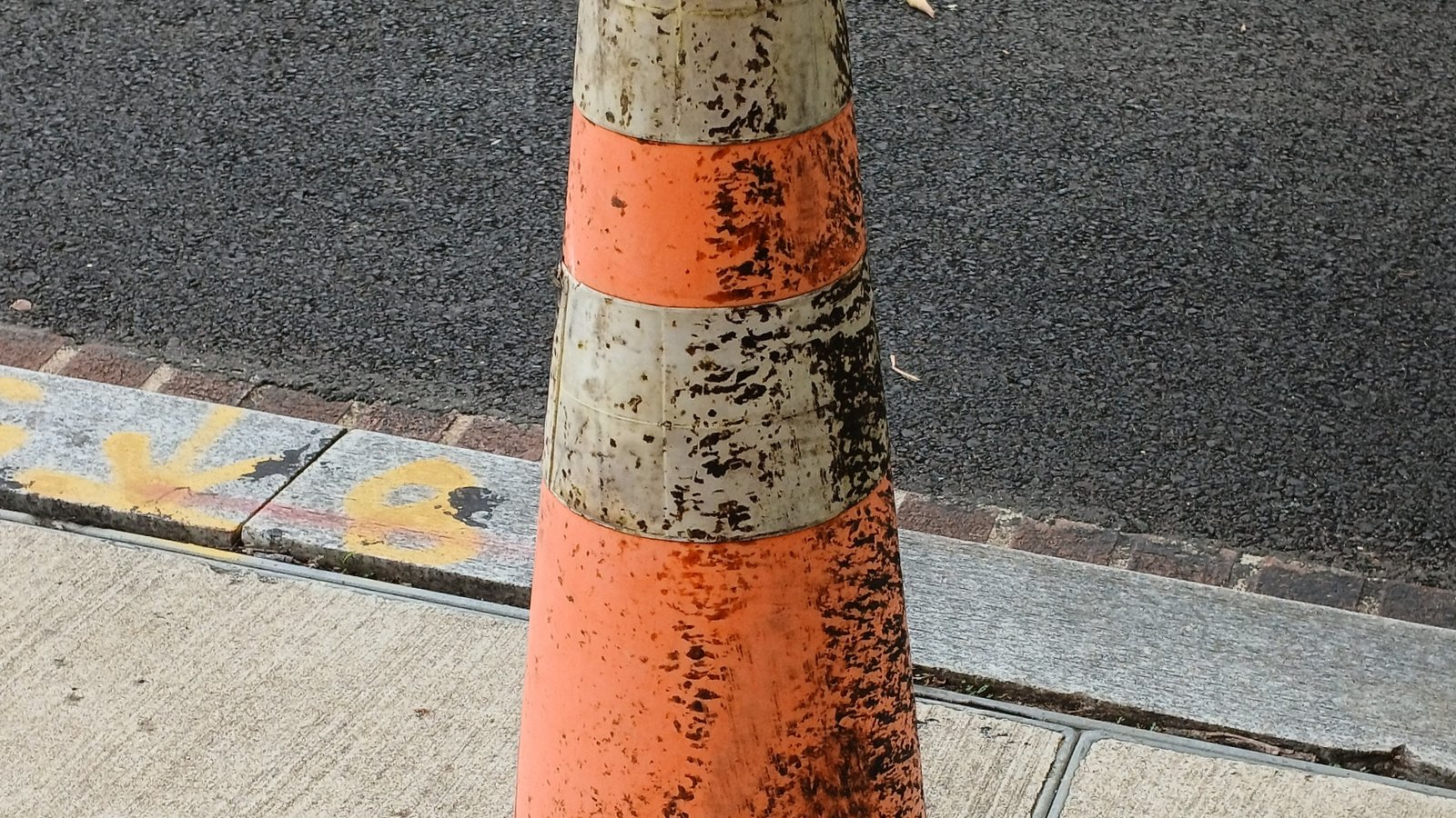 A generic orange traffic cone beside a roadway. This is not a photograph of this crash.