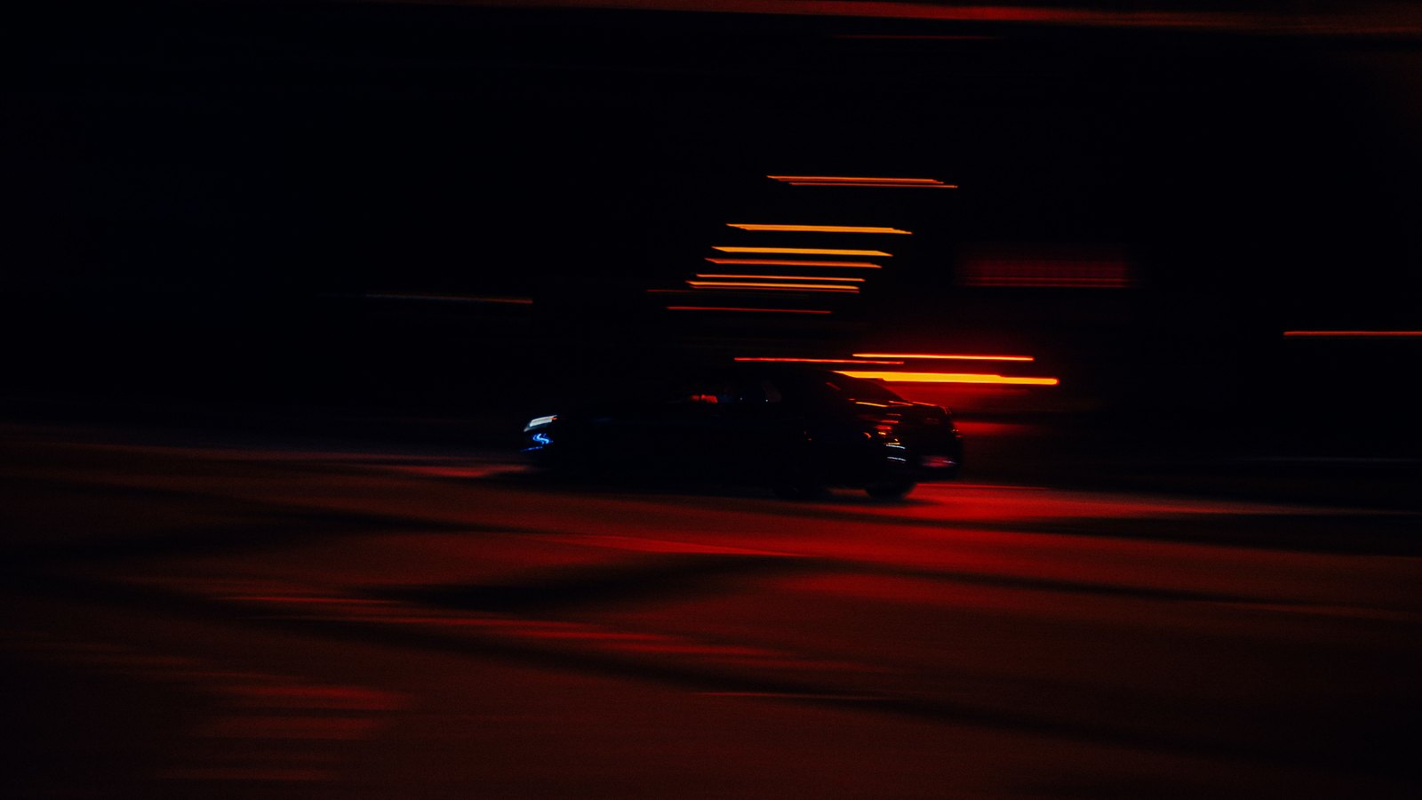 A car passing through red light at night, not a photograph of this event.