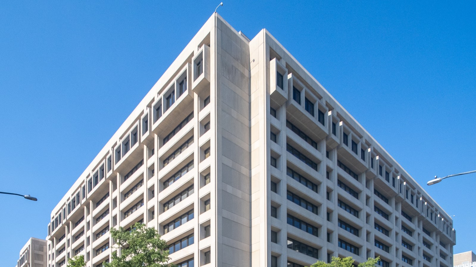 The upper floors of the International Monetary Fund headquarters in Washington beneath a blue sky.