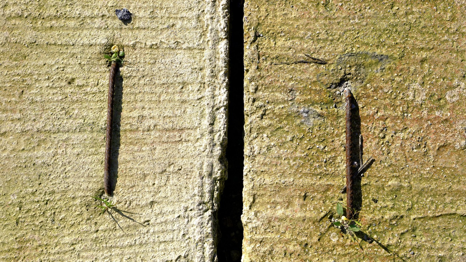 A close crop of weathered concrete slabs with two rusted steel bars set into them, used as an illustration. It carries no signage, no vehicle and no person, and it is not a photograph of this crash or of Immokalee Road.